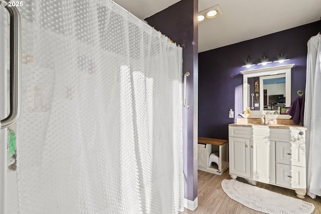 full bath with a shower with curtain, vanity, baseboards, and wood finished floors