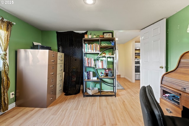 office space with light wood-style flooring and baseboards