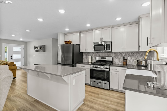 5820 El Mar Ave, Lincoln City, OR 97367 - kitchen featuring stainless steel appliances, tasteful backsplash, a center island, white cabinetry, and recessed lighting