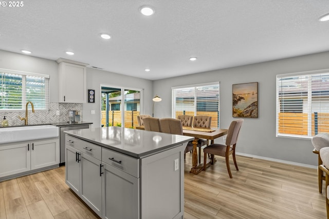 5820 El Mar Ave, Lincoln City, OR 97367 - kitchen with a sink, stainless steel dishwasher, light wood-style floors, backsplash, and recessed lighting