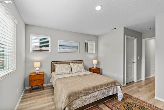 5820 El Mar Ave, Lincoln City, OR 97367 - bedroom with light wood-type flooring, baseboards, and a textured ceiling