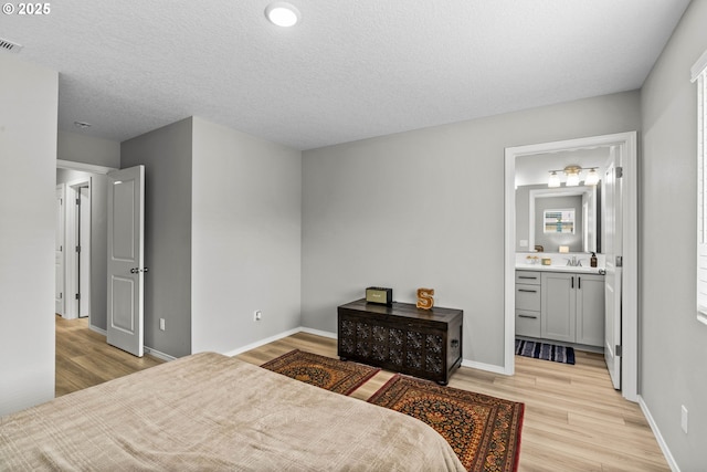 5820 El Mar Ave, Lincoln City, OR 97367 - bedroom with light wood-type flooring, baseboards, ensuite bath, and a sink