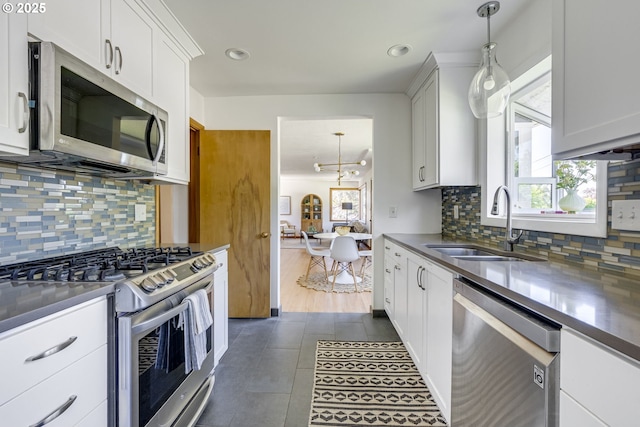 6220 SW 45th Ave, Portland, OR 97221 - kitchen with appliances with stainless steel finishes, a sink, healthy amount of natural light, dark tile patterned floors, and recessed lighting