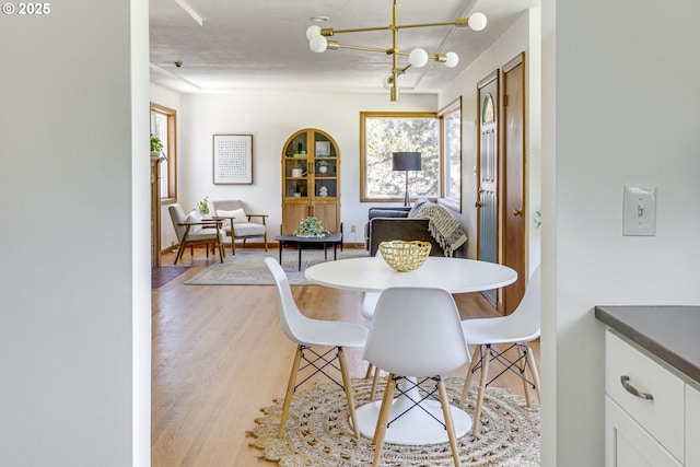 6220 SW 45th Ave, Portland, OR 97221 - dining space with plenty of natural light, light wood finished floors, and a chandelier