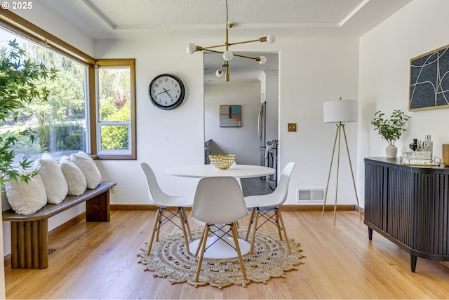 6220 SW 45th Ave, Portland, OR 97221 - dining area with light wood-type flooring, baseboards, and a chandelier