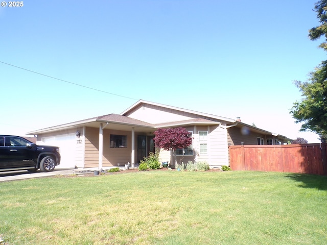 single story home with fence, an attached garage, and a front lawn