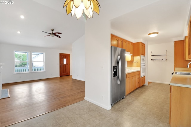 kitchen featuring a sink, light floors, stainless steel fridge with ice dispenser, and light countertops