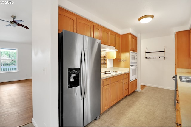 kitchen featuring under cabinet range hood, white appliances, light countertops, light floors, and ceiling fan