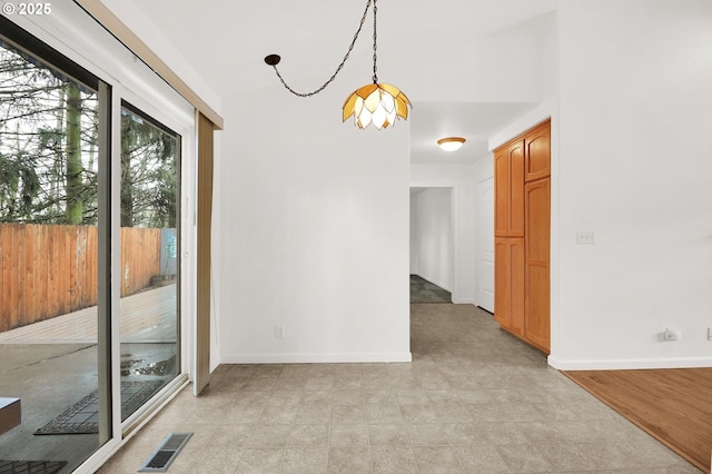 unfurnished dining area featuring visible vents and baseboards