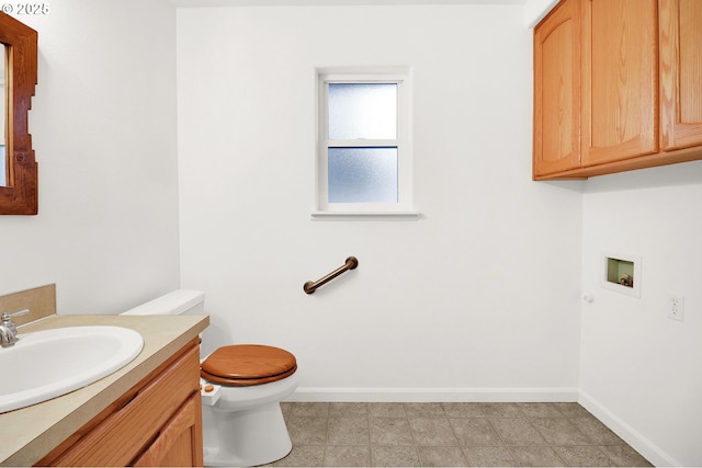 bathroom featuring toilet, vanity, and baseboards