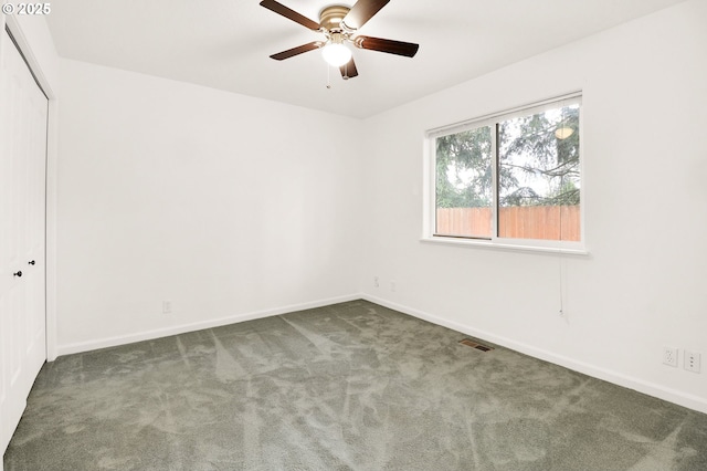 empty room featuring baseboards, visible vents, carpet floors, and ceiling fan