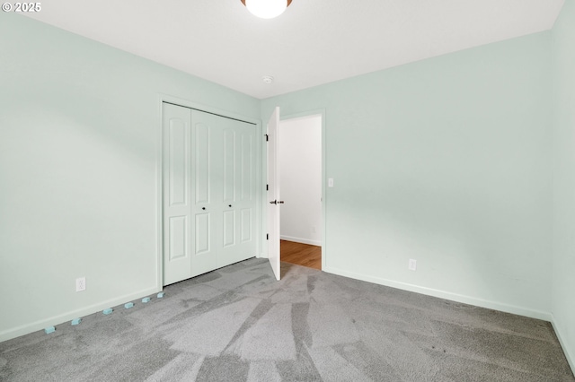 unfurnished bedroom featuring a closet, baseboards, and carpet floors