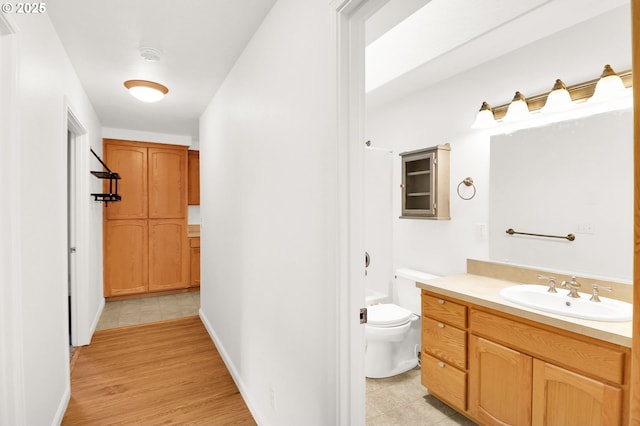 bathroom featuring toilet, vanity, and wood finished floors