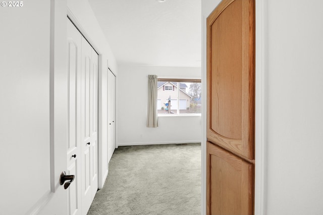 corridor with carpet flooring and baseboards