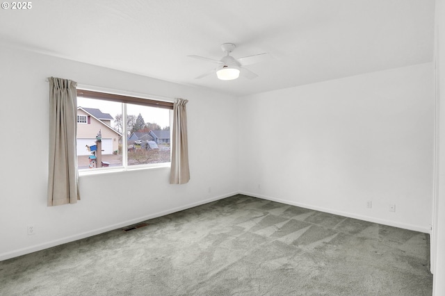 carpeted empty room with a ceiling fan, visible vents, and baseboards