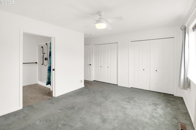 unfurnished bedroom featuring baseboards, visible vents, carpet floors, two closets, and connected bathroom