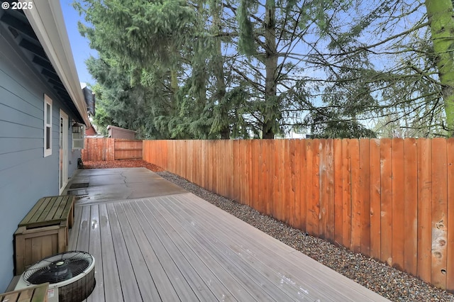 wooden deck with a patio area and a fenced backyard