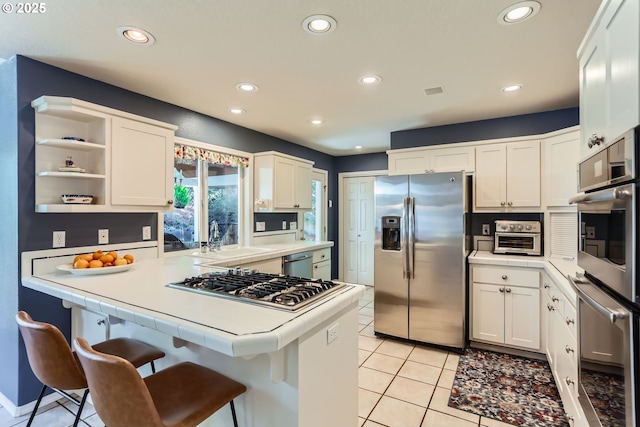 8650 SW Turquoise Loop, Beaverton, OR 97007 - kitchen with appliances with stainless steel finishes, a sink, a kitchen breakfast bar, recessed lighting, and light tile patterned floors