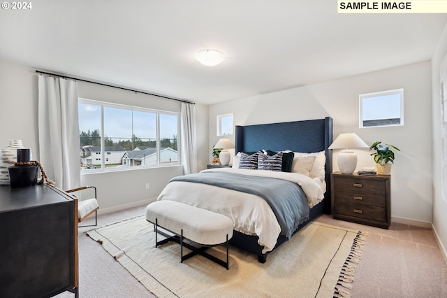 bedroom with light carpet and baseboards