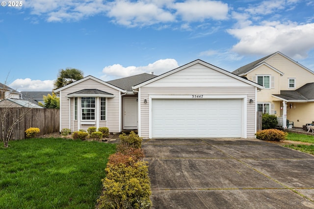 view of front of property featuring fence, a front yard, driveway, and a garage
