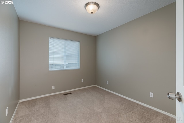 unfurnished room with carpet floors, baseboards, and visible vents