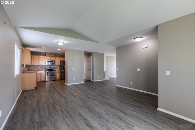 unfurnished living room with baseboards, a sink, lofted ceiling, and dark wood-type flooring