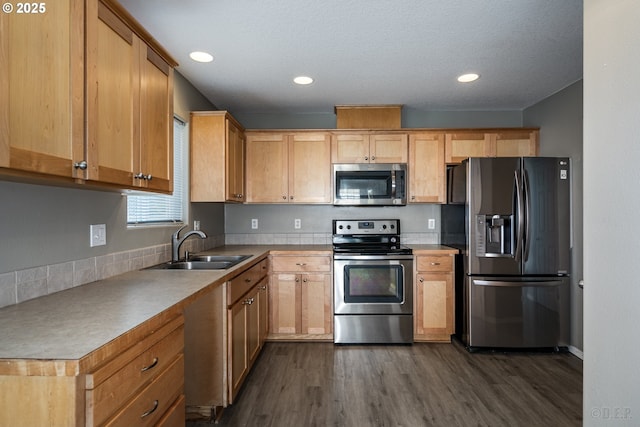 kitchen featuring dark wood-style flooring, appliances with stainless steel finishes, a sink, and recessed lighting