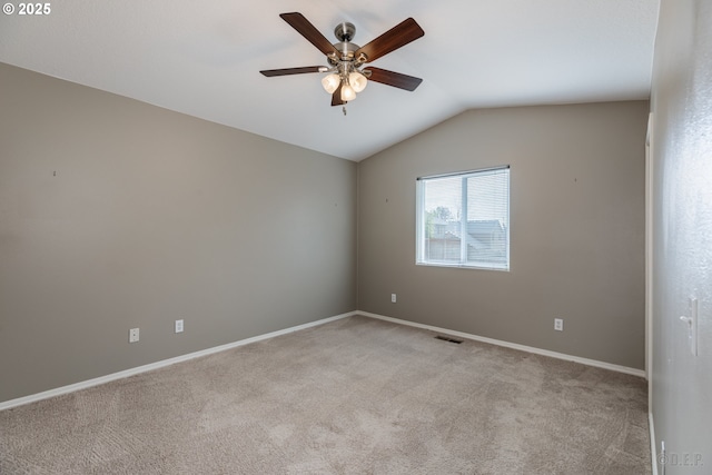 unfurnished room with light colored carpet, a ceiling fan, baseboards, and vaulted ceiling