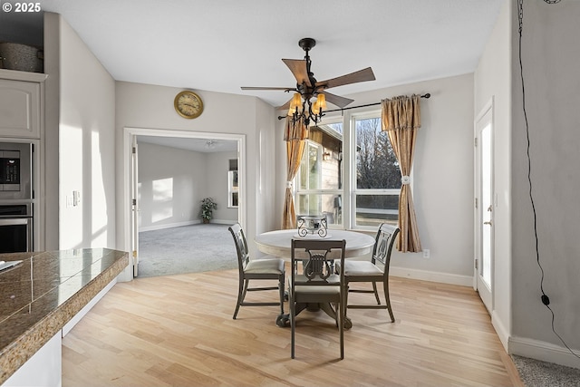 dining space with light hardwood / wood-style floors and ceiling fan