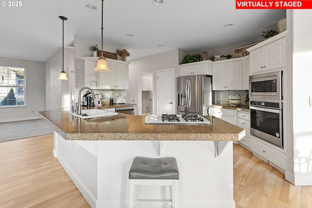 kitchen featuring stainless steel appliances, sink, white cabinets, and decorative backsplash