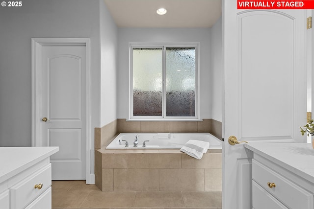 bathroom featuring vanity, tile patterned flooring, and tiled bath