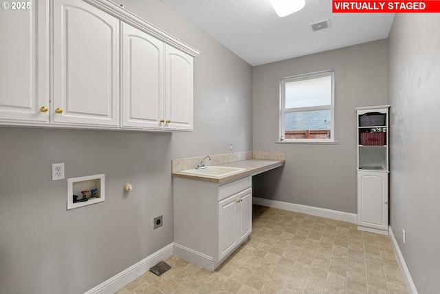 clothes washing area featuring gas dryer hookup, sink, cabinets, washer hookup, and electric dryer hookup