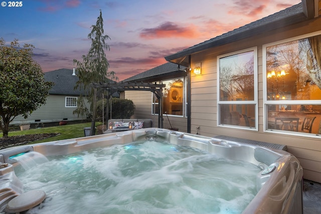 pool at dusk with a hot tub and a pergola