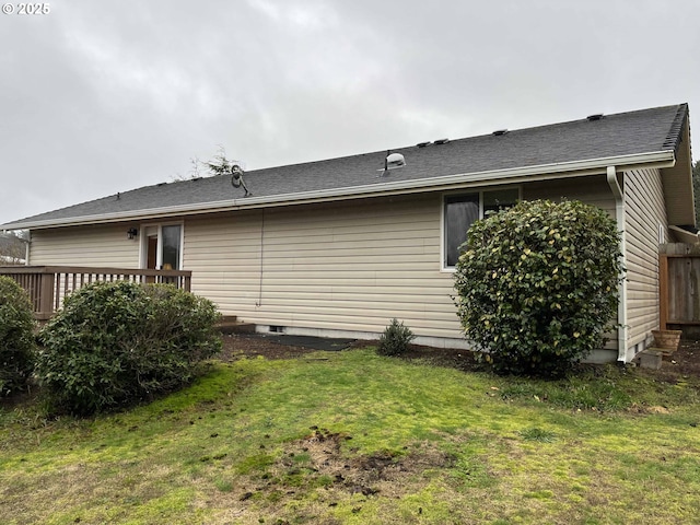 view of home's exterior with a wooden deck and a lawn