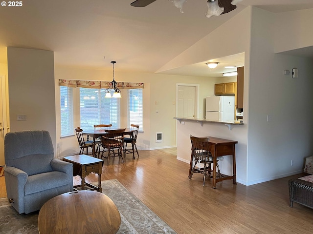 dining area with lofted ceiling, hardwood / wood-style floors, and ceiling fan