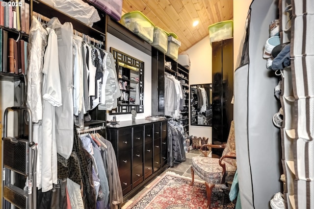 spacious closet with vaulted ceiling and stone finish floor