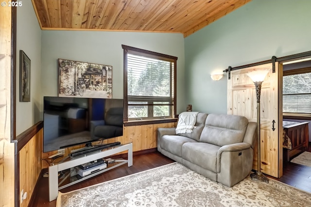 living area featuring a barn door, wood finished floors, wood ceiling, vaulted ceiling, and wainscoting