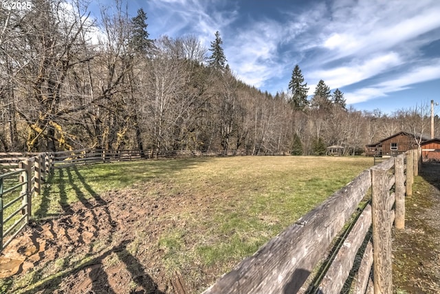 view of yard with fence and a view of trees