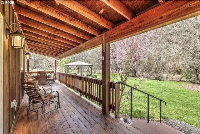 wooden terrace featuring a yard and a gazebo