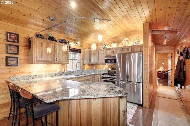 kitchen with appliances with stainless steel finishes, wood ceiling, vaulted ceiling, a peninsula, and wooden walls
