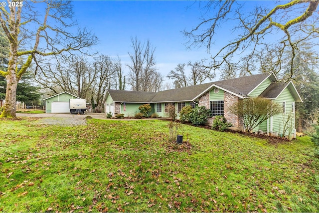 single story home featuring a front yard, a garage, and an outbuilding