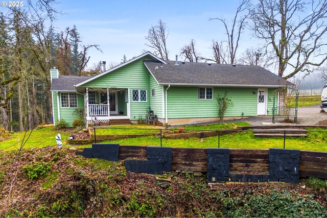 back of property featuring a yard and a porch