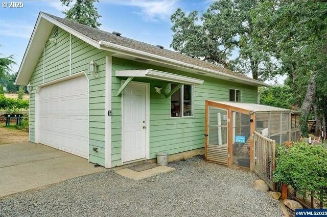 back of house with a garage and an outdoor structure