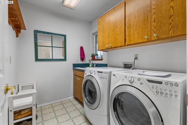 laundry room featuring washing machine and dryer and cabinets