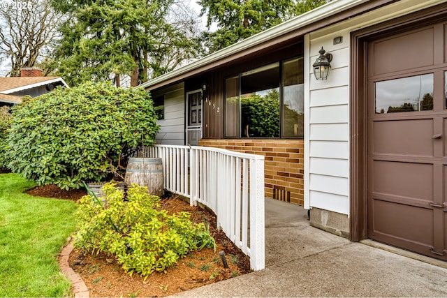 doorway to property with brick siding and a porch