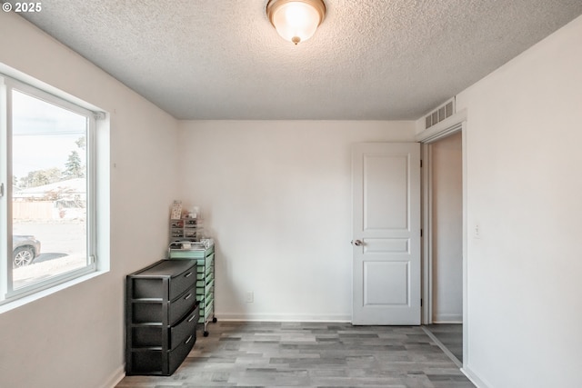 empty room featuring light hardwood / wood-style flooring and a textured ceiling