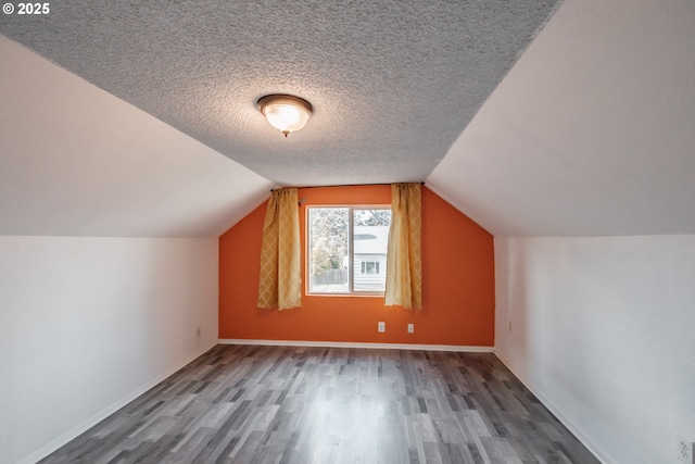 bonus room with hardwood / wood-style flooring, lofted ceiling, and a textured ceiling