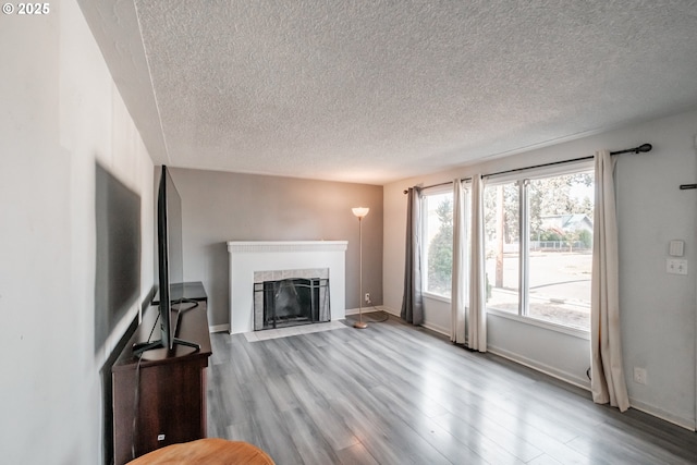 unfurnished living room featuring light hardwood / wood-style flooring and a textured ceiling