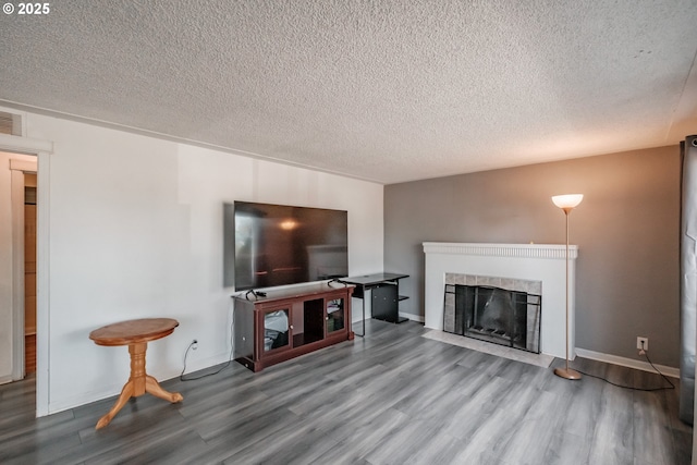 living room featuring hardwood / wood-style floors, a textured ceiling, and a fireplace