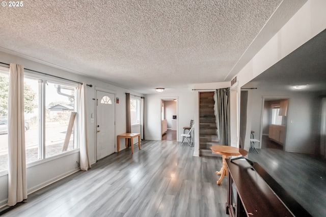 foyer entrance with hardwood / wood-style floors and a textured ceiling